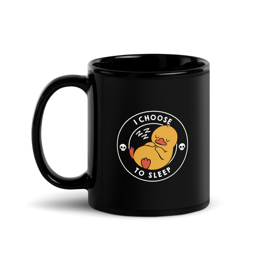 A cute, cartoonish yellow duck is peacefully sleeping with a contented expression. Its webbed feet and wings are tucked in. Around it, the words 'I Choose to Sleep' are inscribed in white letters. Two small skulls accompany this text, adding a humorous, edgy touch. The design is simple, charming, and playful, appealing to fans of ironic, whimsical art.