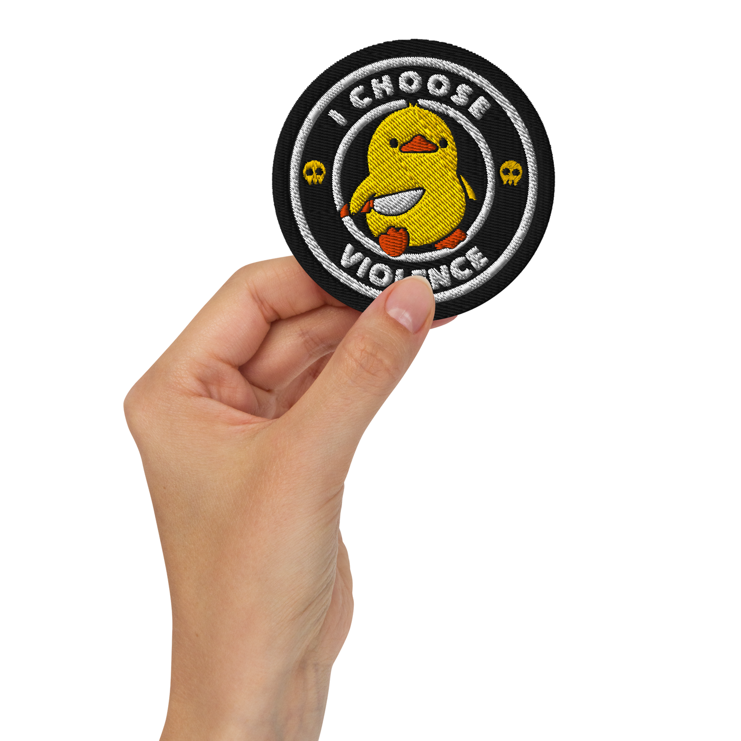 The image displays a cute, cartoon-style yellow duck character holding a knife with a determined expression. The duck is centered inside a circular design with the text 'I CHOOSE FIGHT' around it. Two small skulls flanking the duck add a humorous, combative touch to the design.