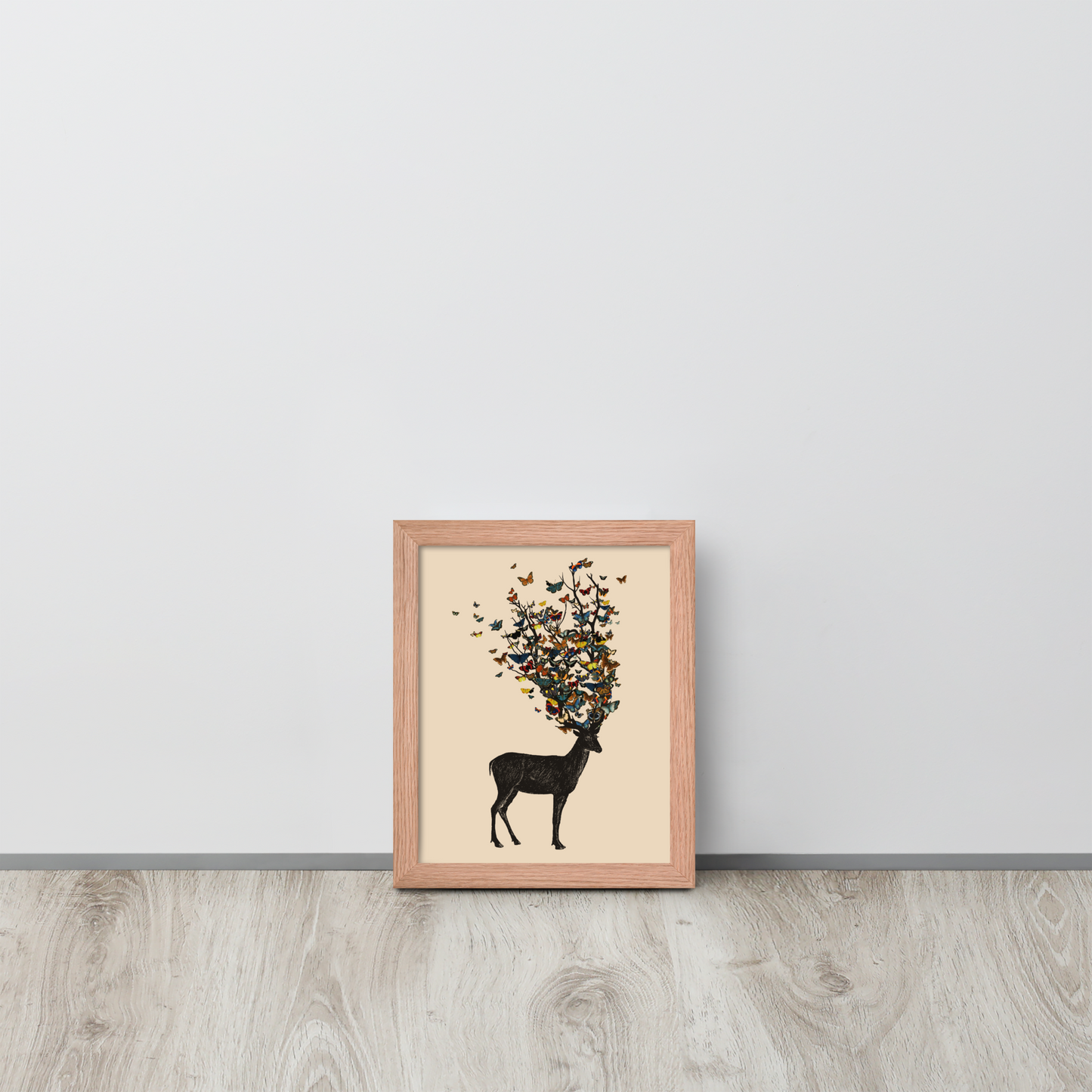 The image depicts a dark, silhouetted deer standing on a neutral background. Instead of branches, its antlers transform into a swirling cloud of vibrant, colorful butterflies that extend upwards and outward. The mix of organic and ethereal elements creates a captivating and whimsical visual contrast.