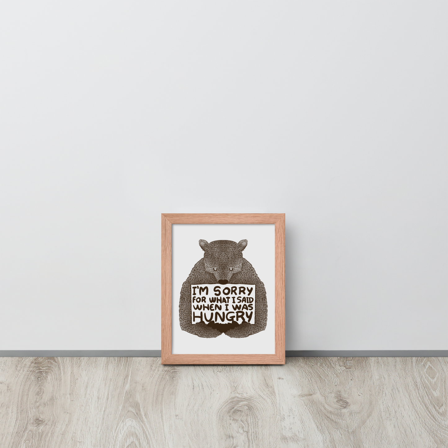 The image shows a humorous, detailed illustration of a bear, drawn in a hand-drawn style, holding a sign that reads 'I'm sorry for what I said when I was hungry.' The bear appears to be apologizing in a comical, endearing manner, making it a relatable and light-hearted design.