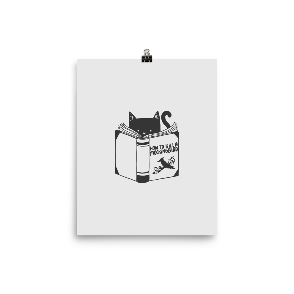 A black and white illustration features a cat peeking over an open book titled 'How to Kill a Mockingbird,' playfully altering the classic novel's title. The cat has a heart-shaped nose and simple, cute facial features. The design is whimsical and ironic, combining classic literature with a humorous twist.