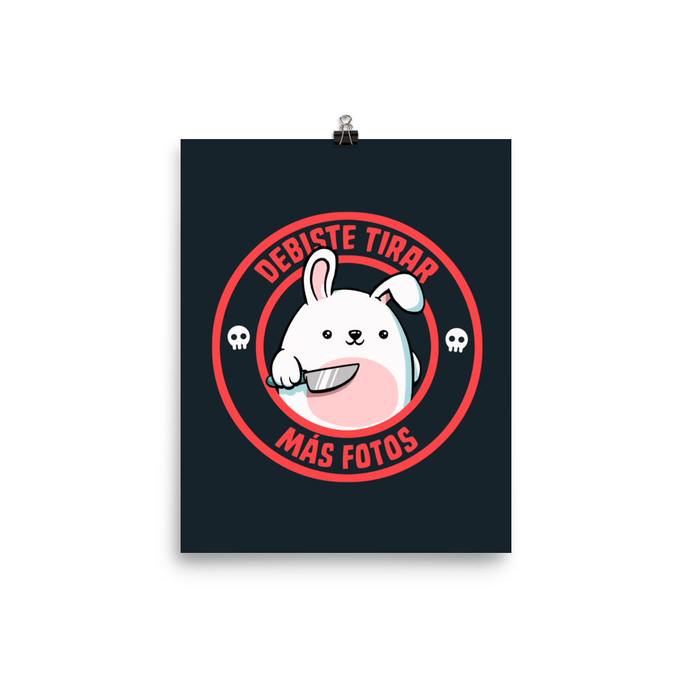 A cute white cartoon bunny with a pink belly stands holding a large kitchen knife in one paw. Surrounding the bunny is a red circular border with the words 'DEBISTE TIRAR MÁS FOTOS'. Small skull icons are on either side of the circle. The overall tone is a mix of adorable and ironic humor.
