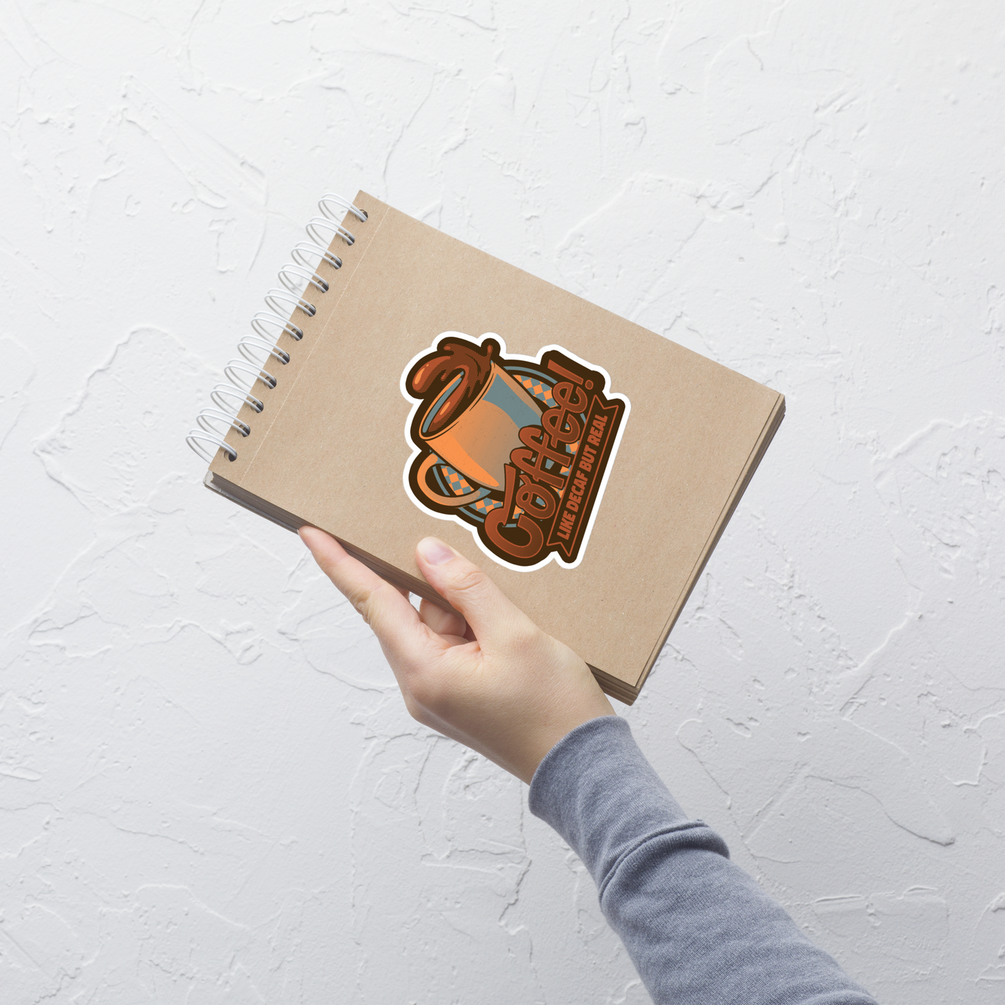 A tilted coffee cup paired with the lettering ‘COFFEE! Like Decaf But Real’. A bold and humorous design made for true coffee lovers who take their caffeine seriously. Perfect as a gift for baristas, caffeine addicts and anyone who believes real coffee is never decaf.