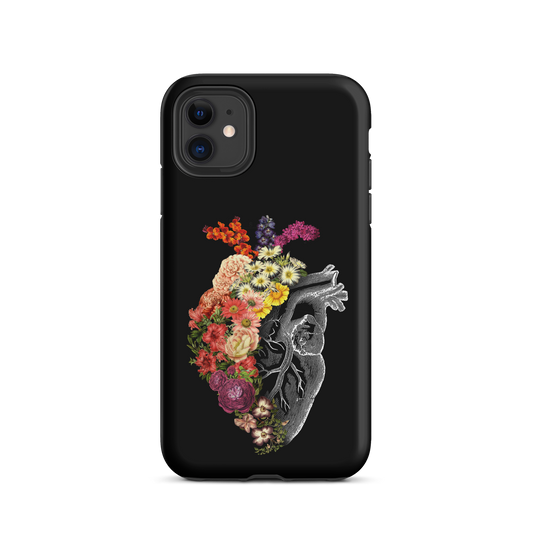 The design is an intricate and anatomical drawing of a human heart on a black background. The left side of the heart morphs into a vibrant assortment of colorful flowers, including roses, daisies, and other blooming blossoms, creating a striking contrast between the realistic and the surreal, symbolizing the harmony between nature and humanity.