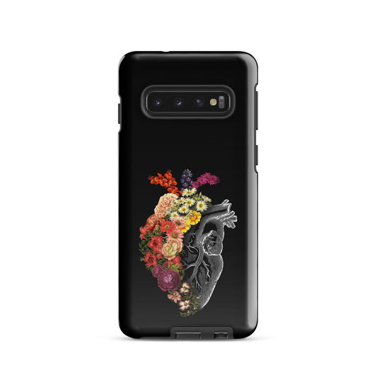 The design is an intricate and anatomical drawing of a human heart on a black background. The left side of the heart morphs into a vibrant assortment of colorful flowers, including roses, daisies, and other blooming blossoms, creating a striking contrast between the realistic and the surreal, symbolizing the harmony between nature and humanity.