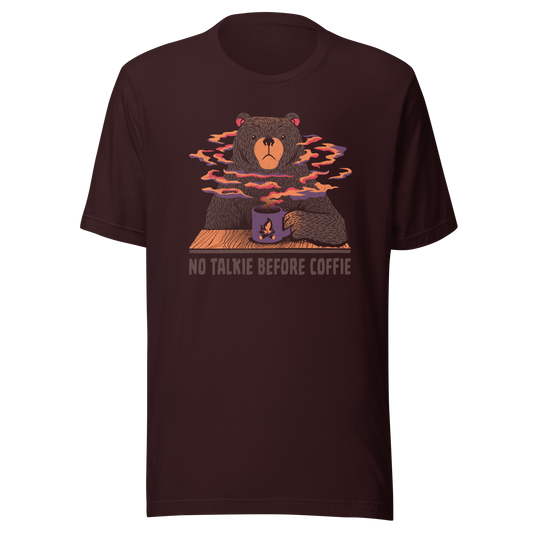 A large brown bear holding a purple coffee cup with a campfire design, with steam rising as if the coffee were piping hot. Below it appears the phrase ‘No Talkie Before Coffie’. A fun design for coffee lovers and anyone who isn’t ready to talk before their first cup.