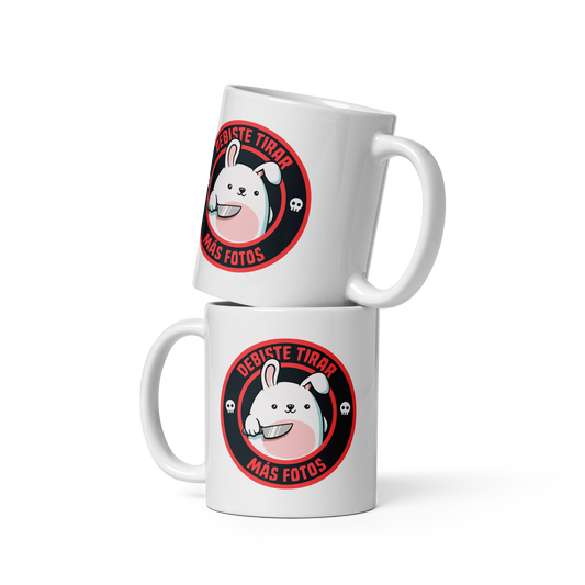 A cute white cartoon bunny with a pink belly stands holding a large kitchen knife in one paw. Surrounding the bunny is a red circular border with the words 'DEBISTE TIRAR MÁS FOTOS'. Small skull icons are on either side of the circle. The overall tone is a mix of adorable and ironic humor.