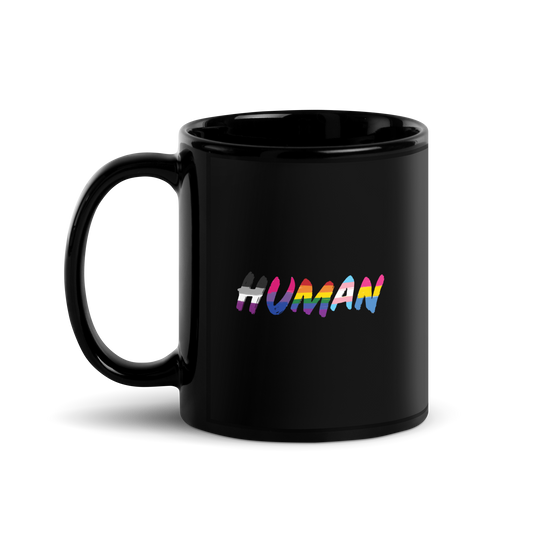 The image displays the word 'HUMAN' in bold, capitalized letters filled with colorful pride flag patterns. The colors within the letters represent different LGBTQ+ pride flags, symbolizing inclusivity and diversity. The background is solid black, which makes the colorful patterns stand out more vibrantly.