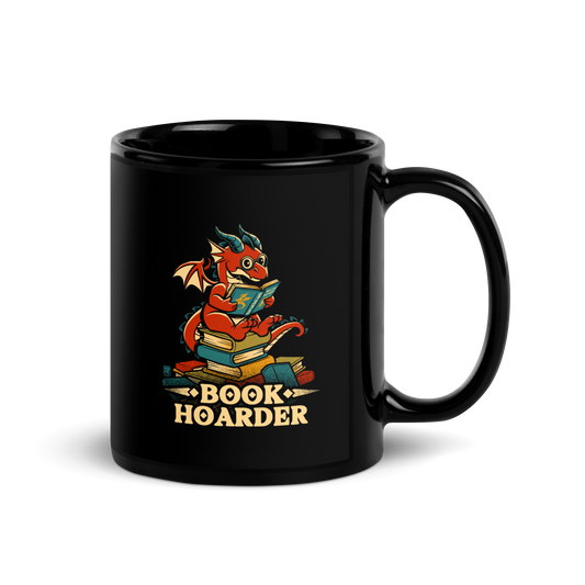 Perched atop his treasure trove of books, this red nerdy dragon is ready to devour epic adventures, magic tales, and fantasy worlds. The words 'BOOK HOARDER' are placed at the bottom of the design.