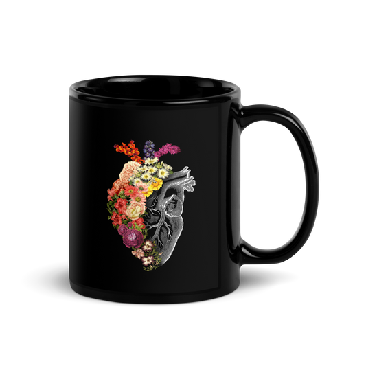 The design is an intricate and anatomical drawing of a human heart on a black background. The left side of the heart morphs into a vibrant assortment of colorful flowers, including roses, daisies, and other blooming blossoms, creating a striking contrast between the realistic and the surreal, symbolizing the harmony between nature and humanity.