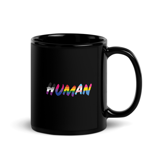 The image displays the word 'HUMAN' in bold, capitalized letters filled with colorful pride flag patterns. The colors within the letters represent different LGBTQ+ pride flags, symbolizing inclusivity and diversity. The background is solid black, which makes the colorful patterns stand out more vibrantly.