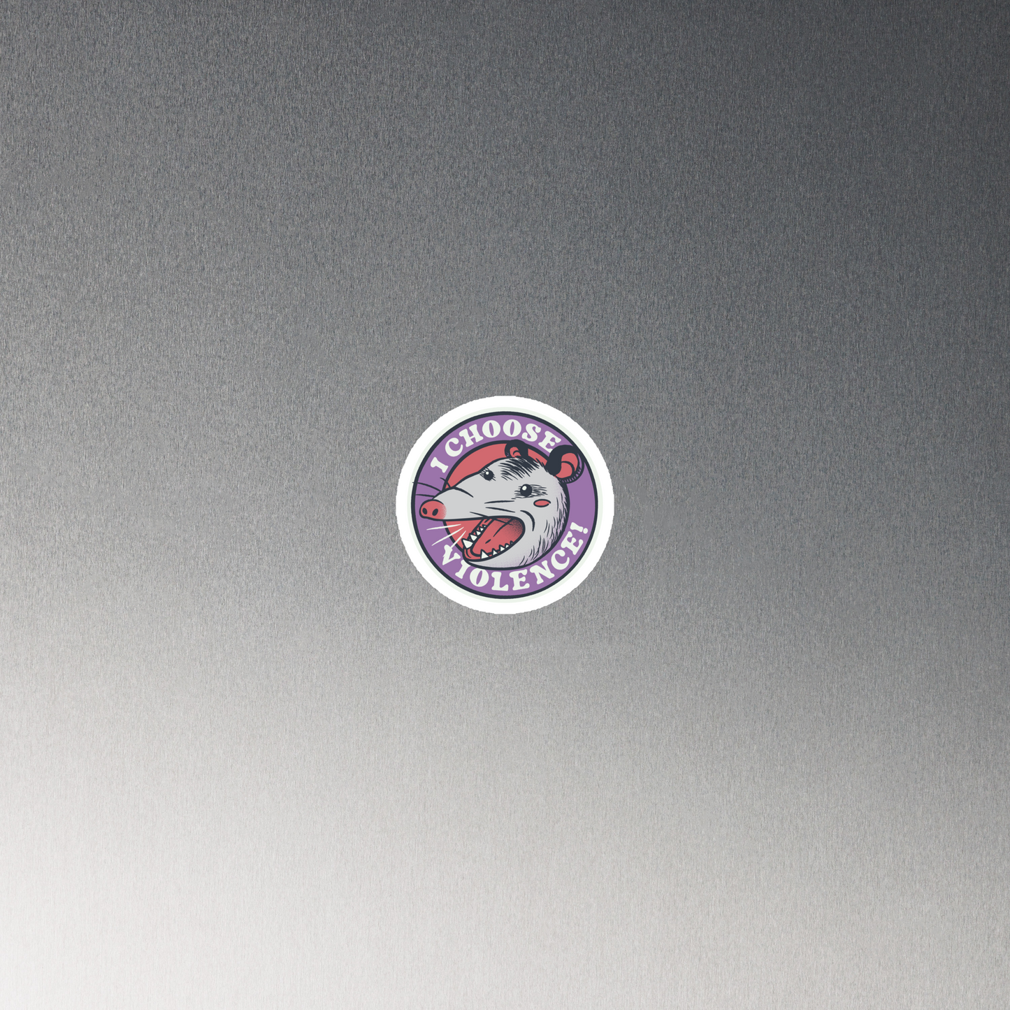A circular design featuring an opossum with an open mouth showing sharp teeth, set against a red and purple background. Surrounding the animal, the text reads 'I Choose Violence!' in bold, white letters. The opossum has a somewhat comical yet aggressive expression. The design has an edgy, cartoon-like style, suitable for various products like t-shirts and stickers.