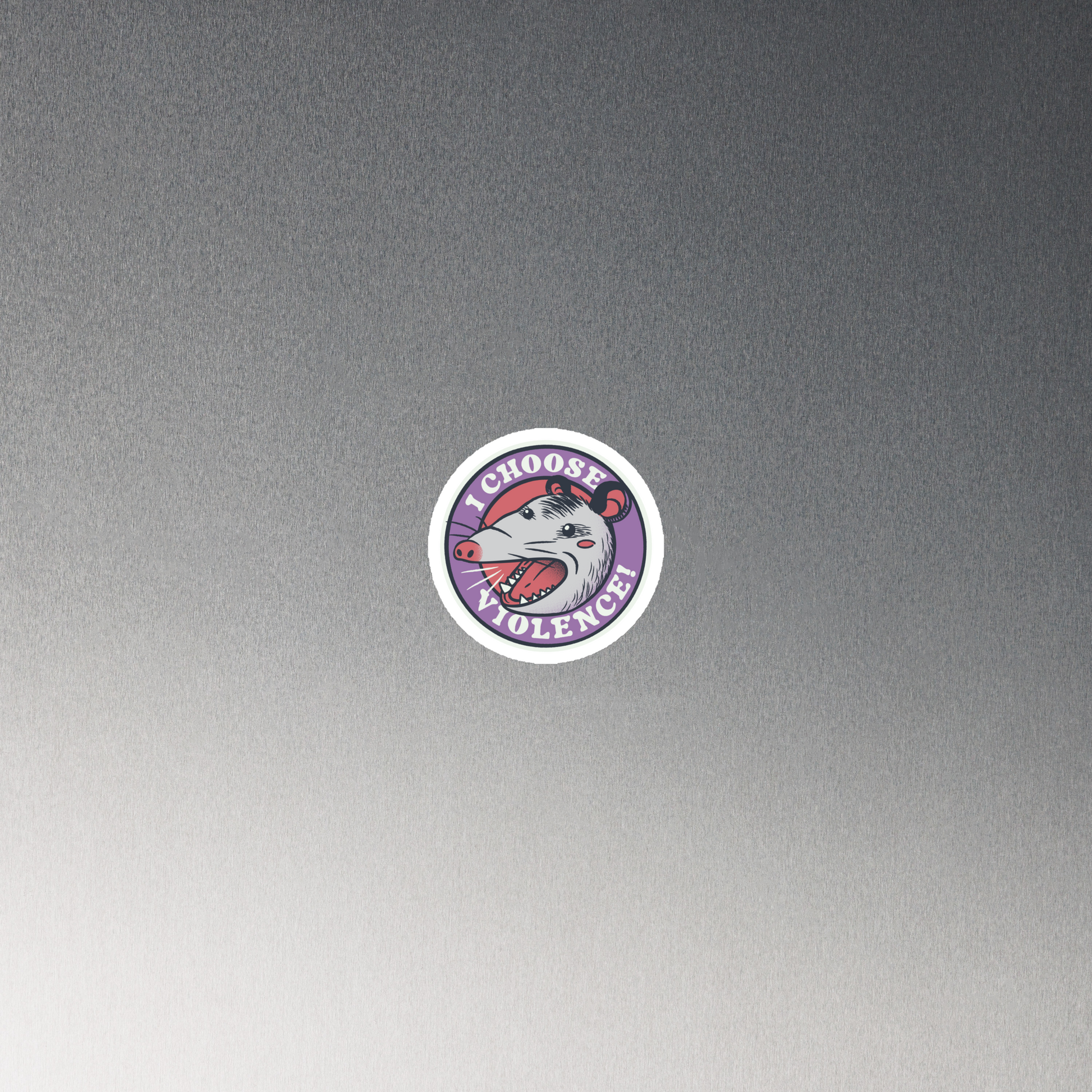 A circular design featuring an opossum with an open mouth showing sharp teeth, set against a red and purple background. Surrounding the animal, the text reads 'I Choose Violence!' in bold, white letters. The opossum has a somewhat comical yet aggressive expression. The design has an edgy, cartoon-like style, suitable for various products like t-shirts and stickers.