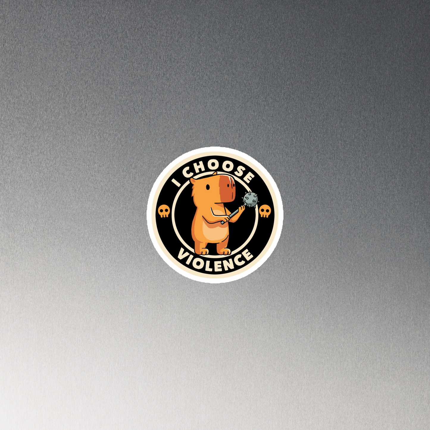 A cute, cartoonish burnt yellow capybara stands holding a spiked mace with a determined expression. Surrounding it is a circular design with the text 'I CHOOSE VIOLENCE' and two small skulls on either side, giving it a humorous yet ironic tone.