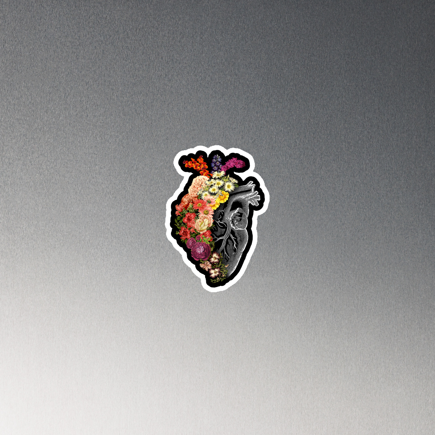 The design is an intricate and anatomical drawing of a human heart on a black background. The left side of the heart morphs into a vibrant assortment of colorful flowers, including roses, daisies, and other blooming blossoms, creating a striking contrast between the realistic and the surreal, symbolizing the harmony between nature and humanity.
