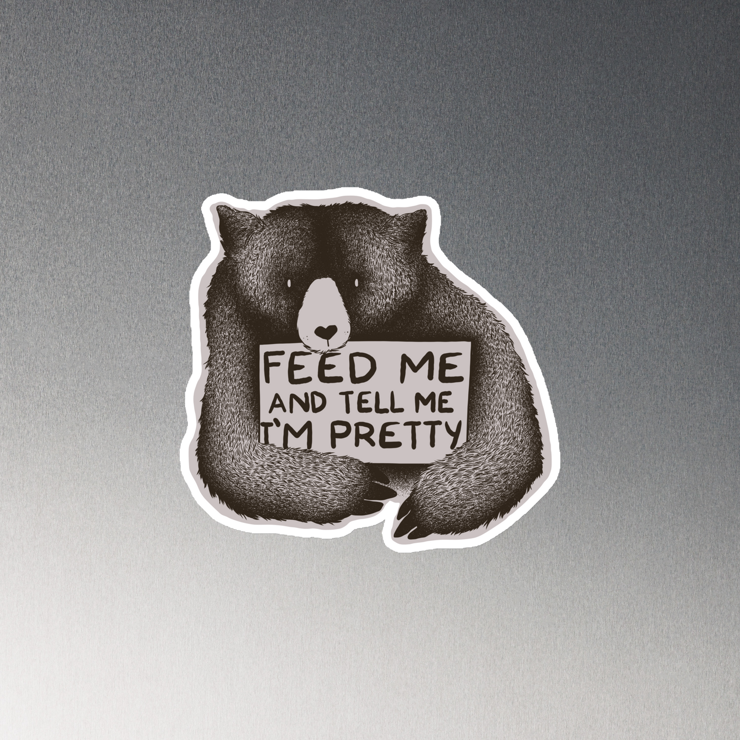 This drawing is of a cute, cartoon-style bear holding a sign with a heart-shaped nose and simple, expressive eyes. The sign reads, 'Feed me and tell me I'm pretty' in a handwritten, playful font. The bear's fur is detailed with fine, textured lines, giving it a cozy, endearing look. The drawing has a monochrome, black-and-white color scheme