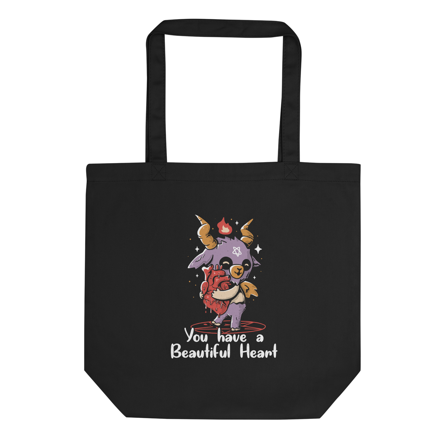 The design features a cute, cartoonish, anthropomorphic goat with big horns and a flame above its head, standing on a red pentagram. The goat has a star on its forehead and is hugging a large, anatomically correct human heart. The text below reads, 'You have a Beautiful Heart'. The image combines elements of occult symbolism with a playful, endearing aesthetic.