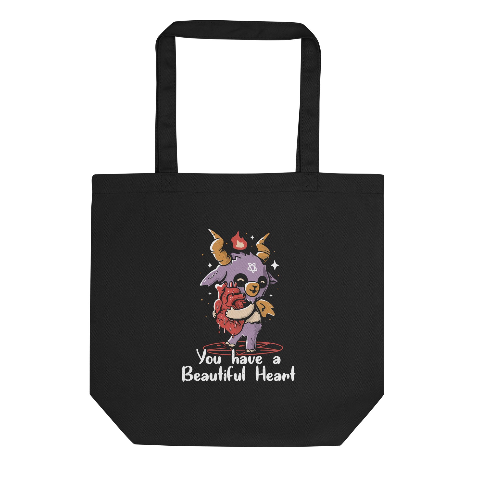 The design features a cute, cartoonish, anthropomorphic goat with big horns and a flame above its head, standing on a red pentagram. The goat has a star on its forehead and is hugging a large, anatomically correct human heart. The text below reads, 'You have a Beautiful Heart'. The image combines elements of occult symbolism with a playful, endearing aesthetic.
