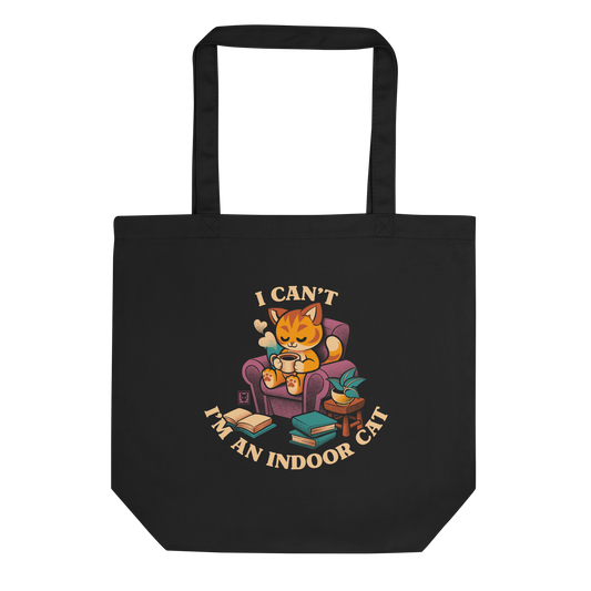 This cozy design features a contented orange cat sipping coffee in a comfy chair, surrounded by books and plants. The following message encircles the design: I CAN'T I'M AN INDOOR CAT.