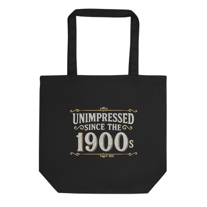 Vintage-style graphic with the phrase “Unimpressed Since the 1900s” in bold distressed lettering, decorated with ornate flourishes and a retro color palette.