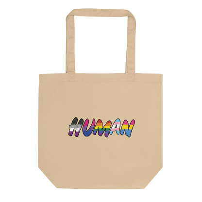 The image displays the word 'HUMAN' in bold, capitalized letters filled with colorful pride flag patterns. The colors within the letters represent different LGBTQ+ pride flags, symbolizing inclusivity and diversity. The background is solid black, which makes the colorful patterns stand out more vibrantly.