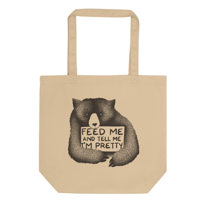 This drawing is of a cute, cartoon-style bear holding a sign with a heart-shaped nose and simple, expressive eyes. The sign reads, 'Feed me and tell me I'm pretty' in a handwritten, playful font. The bear's fur is detailed with fine, textured lines, giving it a cozy, endearing look. The drawing has a monochrome, black-and-white color scheme