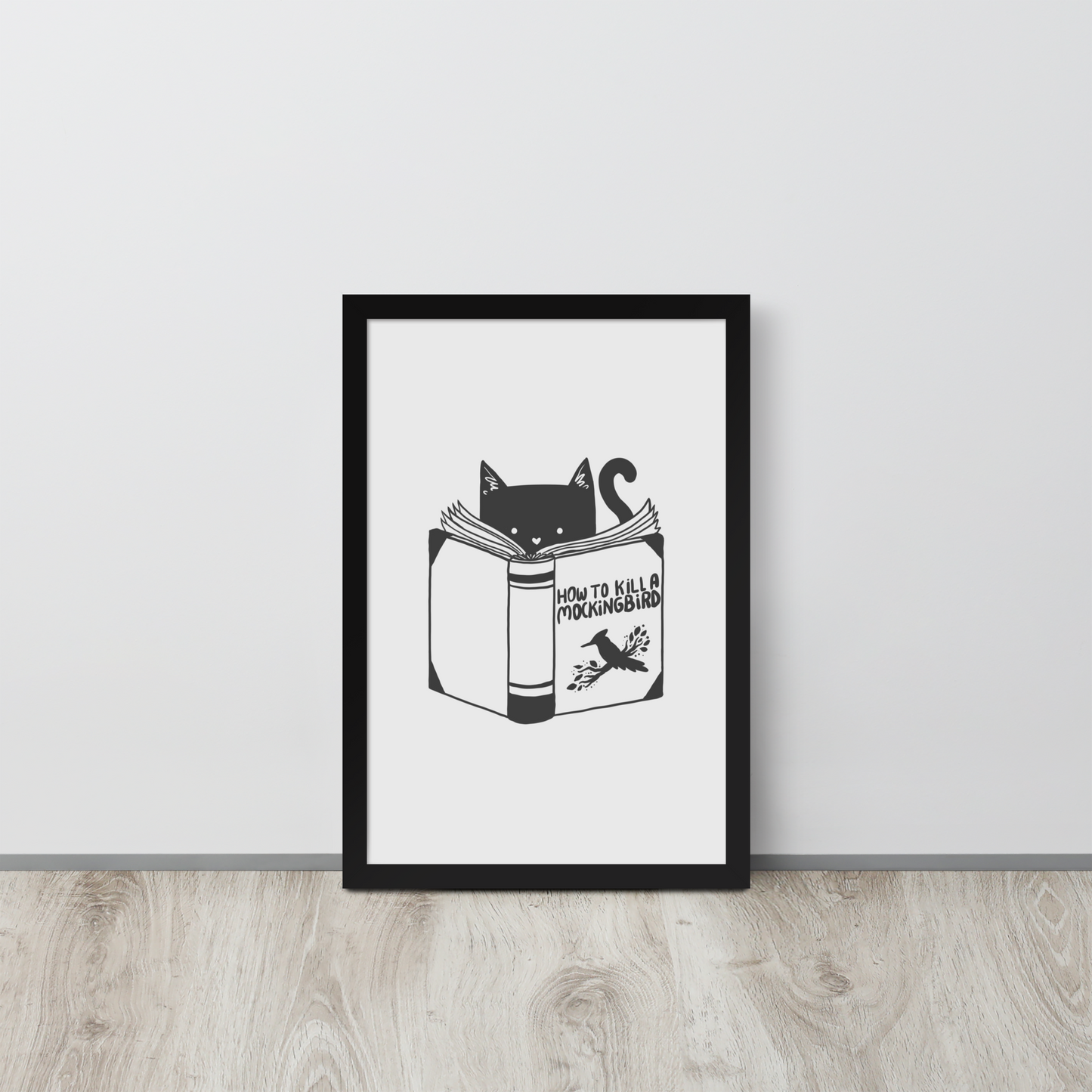 A black and white illustration features a cat peeking over an open book titled 'How to Kill a Mockingbird,' playfully altering the classic novel's title. The cat has a heart-shaped nose and simple, cute facial features. The design is whimsical and ironic, combining classic literature with a humorous twist.