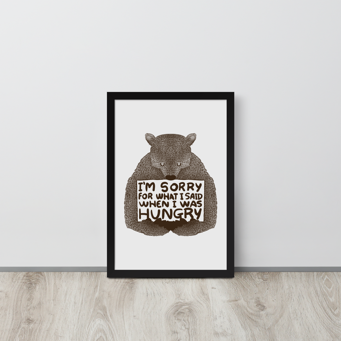 The image shows a humorous, detailed illustration of a bear, drawn in a hand-drawn style, holding a sign that reads 'I'm sorry for what I said when I was hungry.' The bear appears to be apologizing in a comical, endearing manner, making it a relatable and light-hearted design.