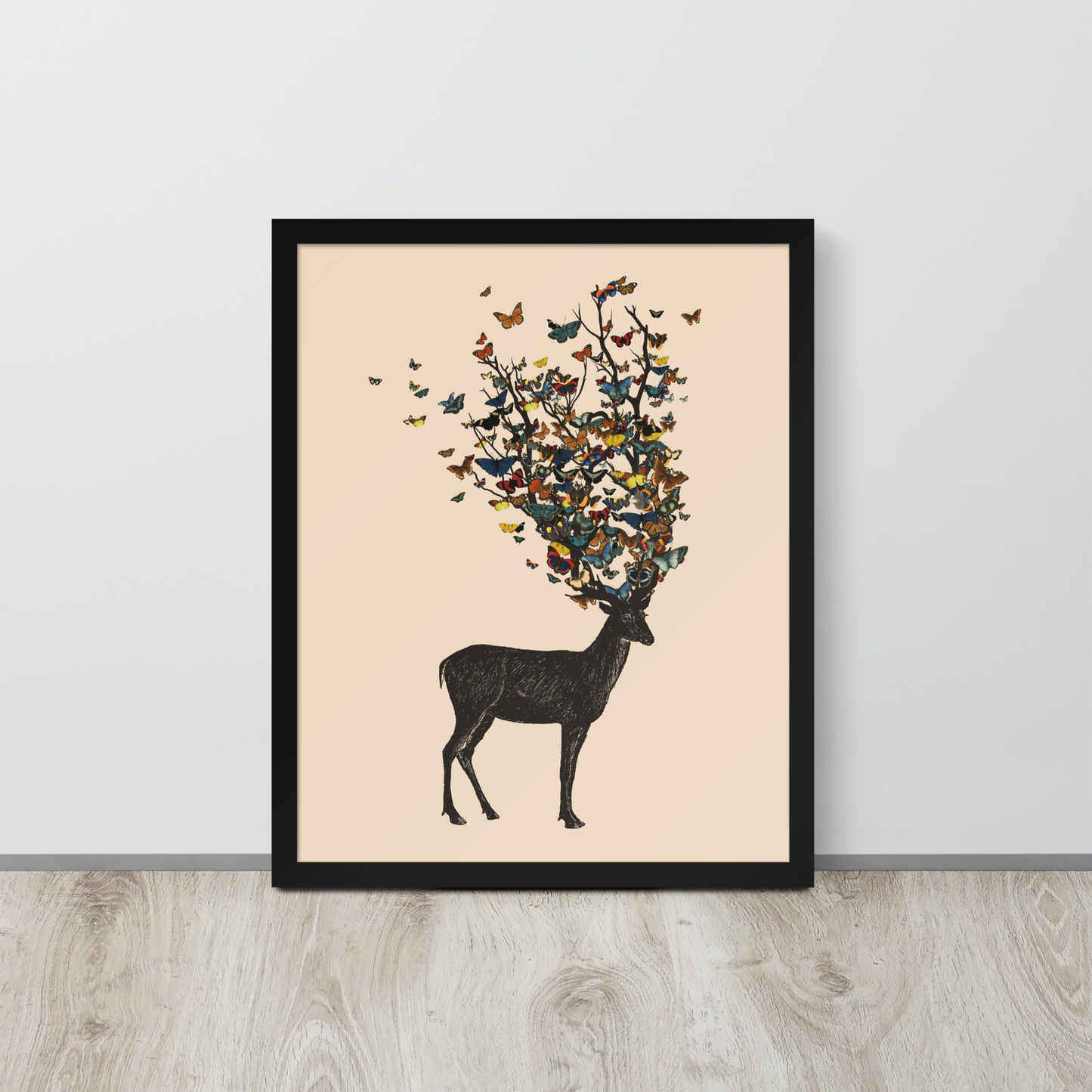 The image depicts a dark, silhouetted deer standing on a neutral background. Instead of branches, its antlers transform into a swirling cloud of vibrant, colorful butterflies that extend upwards and outward. The mix of organic and ethereal elements creates a captivating and whimsical visual contrast.