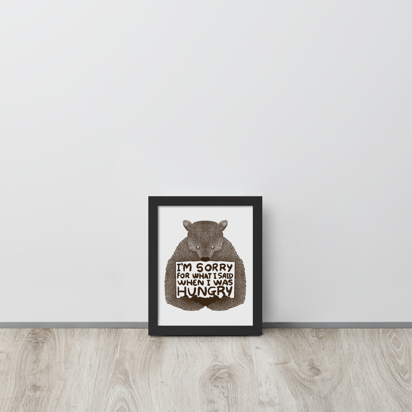 The image shows a humorous, detailed illustration of a bear, drawn in a hand-drawn style, holding a sign that reads 'I'm sorry for what I said when I was hungry.' The bear appears to be apologizing in a comical, endearing manner, making it a relatable and light-hearted design.