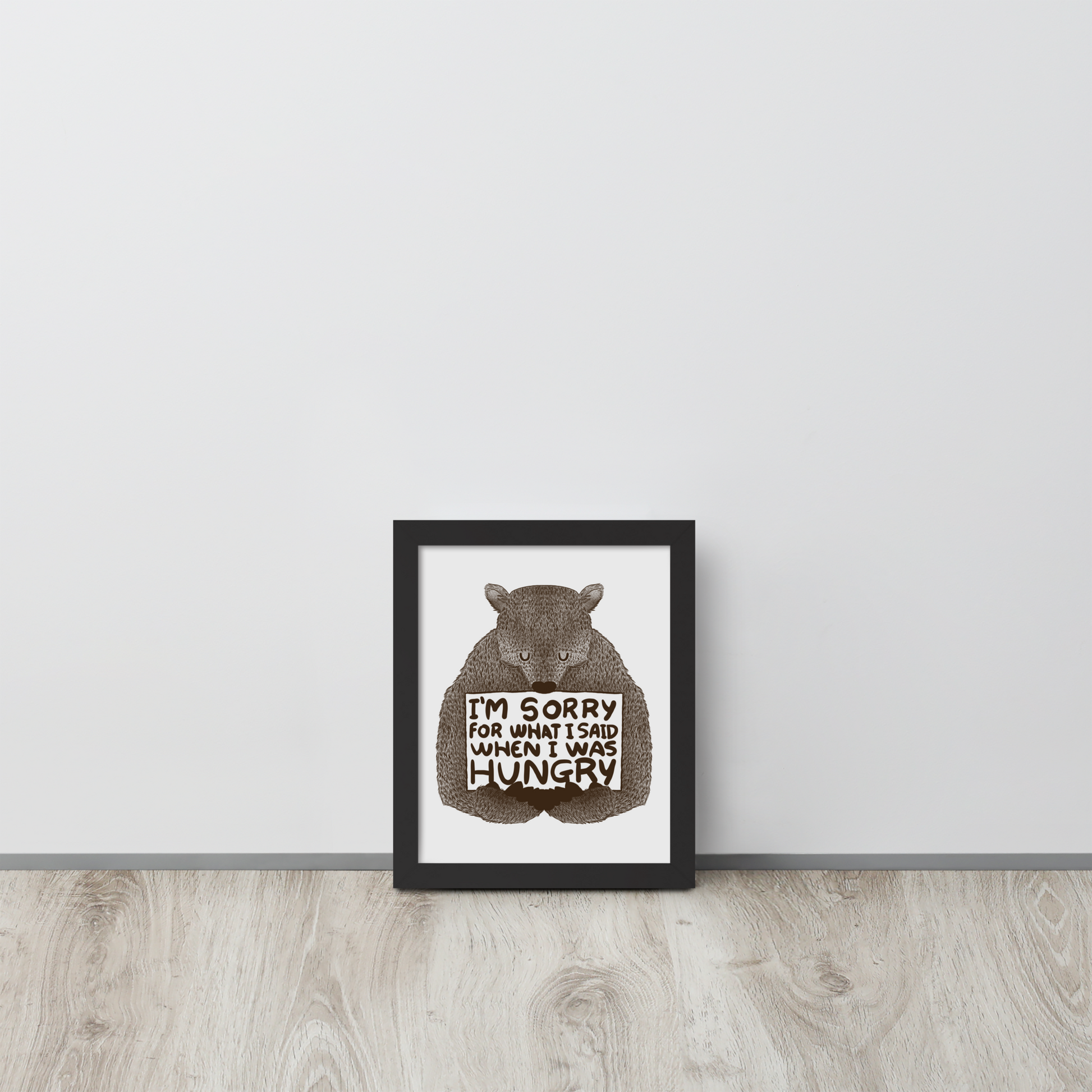 The image shows a humorous, detailed illustration of a bear, drawn in a hand-drawn style, holding a sign that reads 'I'm sorry for what I said when I was hungry.' The bear appears to be apologizing in a comical, endearing manner, making it a relatable and light-hearted design.