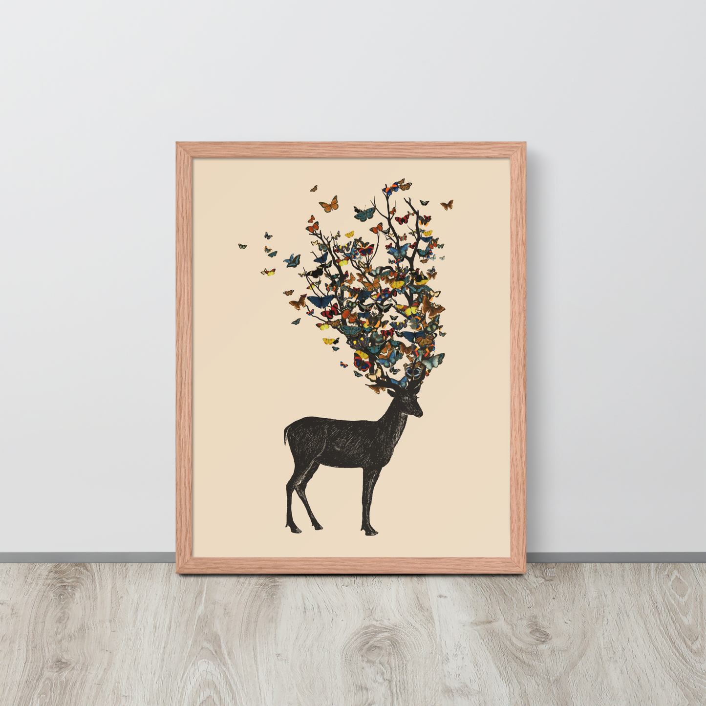 The image depicts a dark, silhouetted deer standing on a neutral background. Instead of branches, its antlers transform into a swirling cloud of vibrant, colorful butterflies that extend upwards and outward. The mix of organic and ethereal elements creates a captivating and whimsical visual contrast.