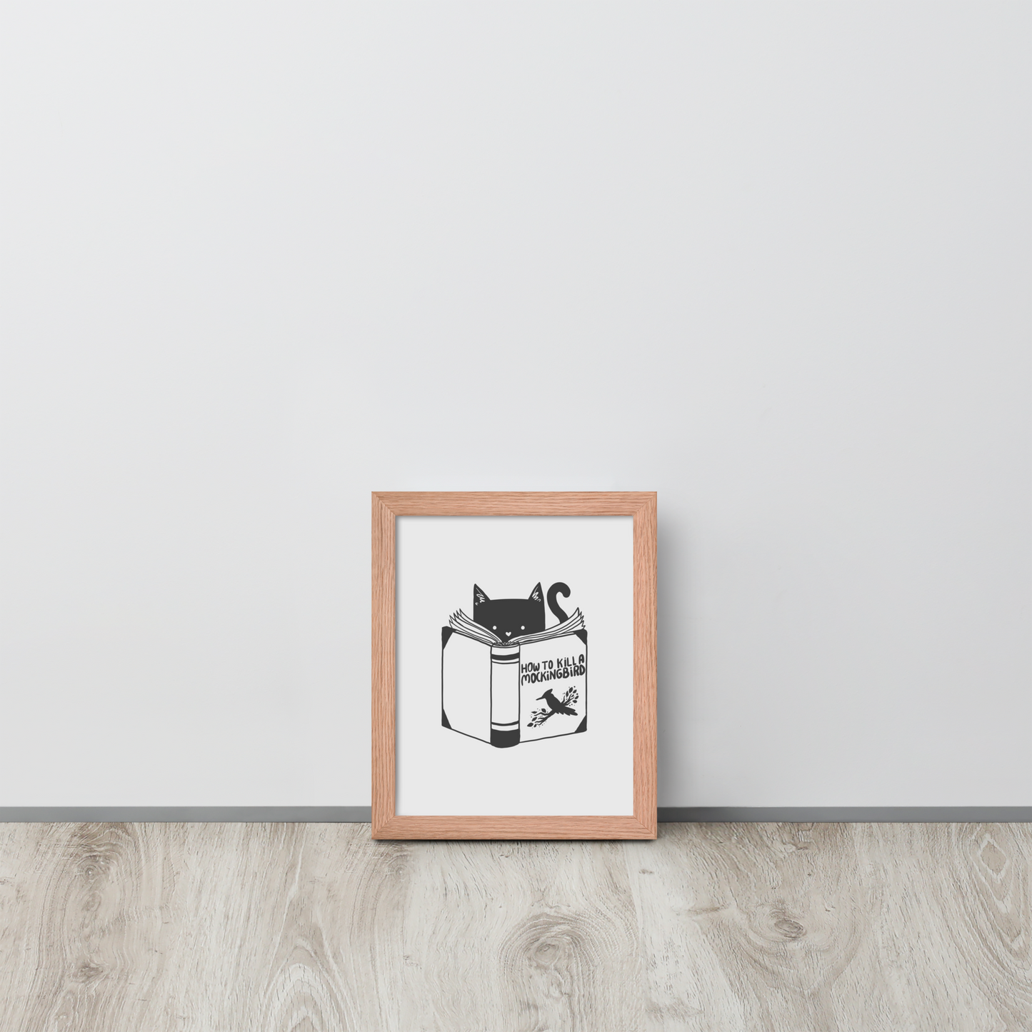 A black and white illustration features a cat peeking over an open book titled 'How to Kill a Mockingbird,' playfully altering the classic novel's title. The cat has a heart-shaped nose and simple, cute facial features. The design is whimsical and ironic, combining classic literature with a humorous twist.