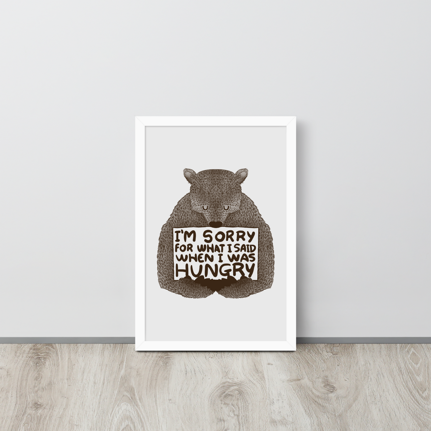 The image shows a humorous, detailed illustration of a bear, drawn in a hand-drawn style, holding a sign that reads 'I'm sorry for what I said when I was hungry.' The bear appears to be apologizing in a comical, endearing manner, making it a relatable and light-hearted design.