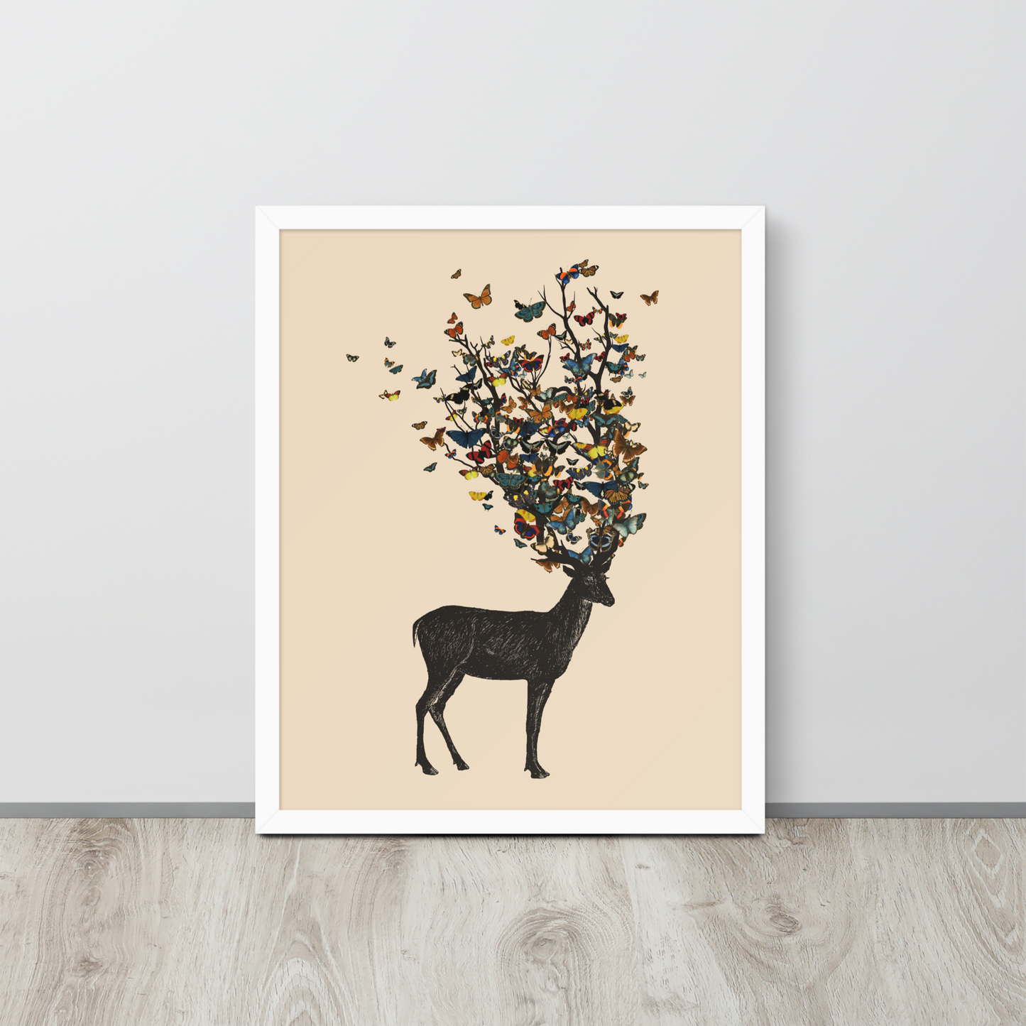 The image depicts a dark, silhouetted deer standing on a neutral background. Instead of branches, its antlers transform into a swirling cloud of vibrant, colorful butterflies that extend upwards and outward. The mix of organic and ethereal elements creates a captivating and whimsical visual contrast.