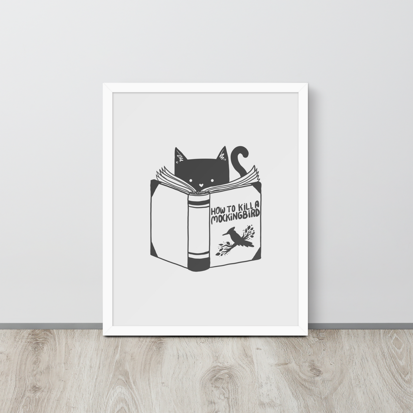 A black and white illustration features a cat peeking over an open book titled 'How to Kill a Mockingbird,' playfully altering the classic novel's title. The cat has a heart-shaped nose and simple, cute facial features. The design is whimsical and ironic, combining classic literature with a humorous twist.