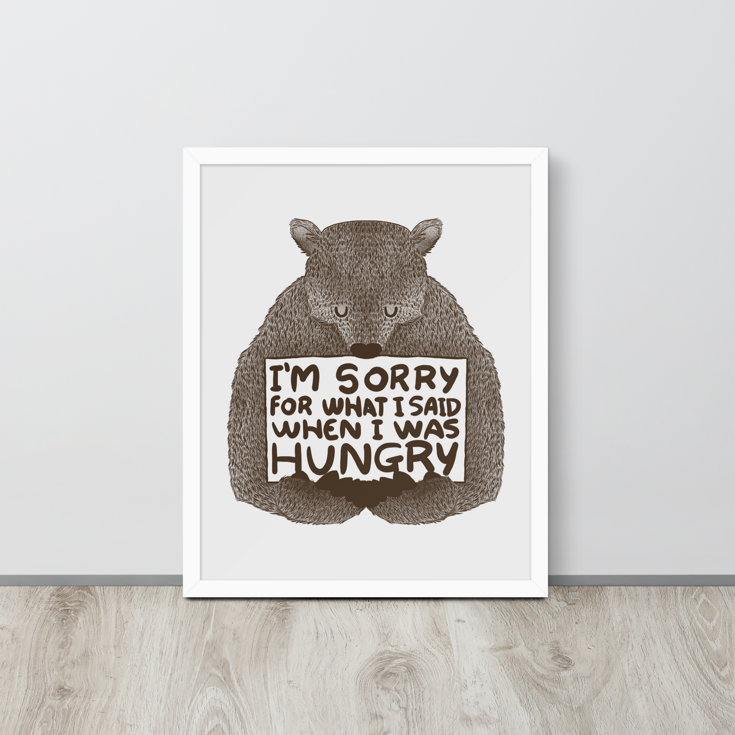 The image shows a humorous, detailed illustration of a bear, drawn in a hand-drawn style, holding a sign that reads 'I'm sorry for what I said when I was hungry.' The bear appears to be apologizing in a comical, endearing manner, making it a relatable and light-hearted design.