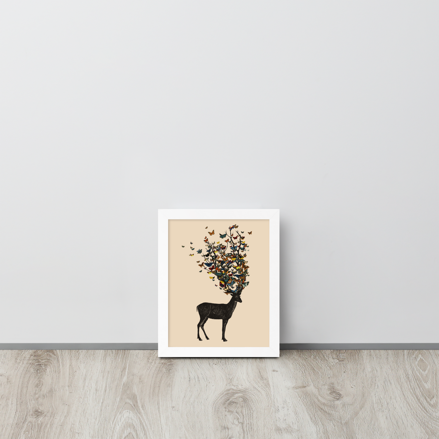 The image depicts a dark, silhouetted deer standing on a neutral background. Instead of branches, its antlers transform into a swirling cloud of vibrant, colorful butterflies that extend upwards and outward. The mix of organic and ethereal elements creates a captivating and whimsical visual contrast.