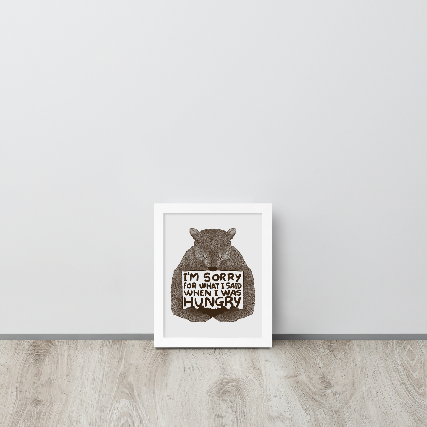 The image shows a humorous, detailed illustration of a bear, drawn in a hand-drawn style, holding a sign that reads 'I'm sorry for what I said when I was hungry.' The bear appears to be apologizing in a comical, endearing manner, making it a relatable and light-hearted design.