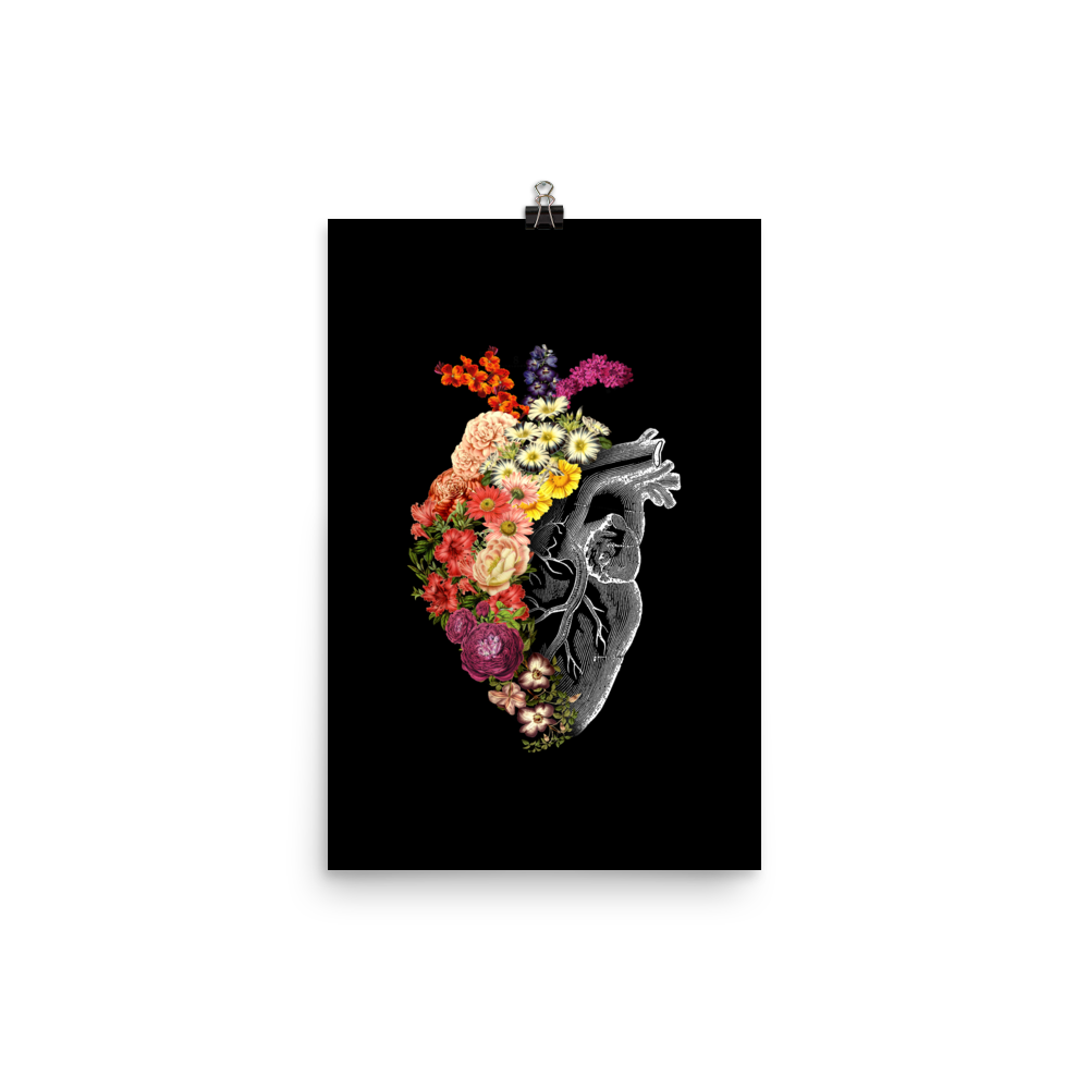 The design is an intricate and anatomical drawing of a human heart on a black background. The left side of the heart morphs into a vibrant assortment of colorful flowers, including roses, daisies, and other blooming blossoms, creating a striking contrast between the realistic and the surreal, symbolizing the harmony between nature and humanity.