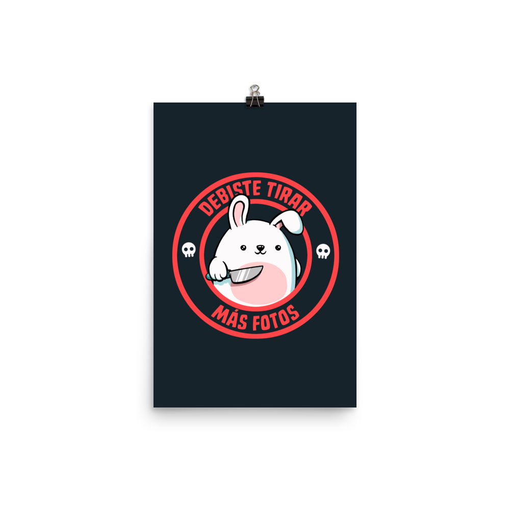 A cute white cartoon bunny with a pink belly stands holding a large kitchen knife in one paw. Surrounding the bunny is a red circular border with the words 'DEBISTE TIRAR MÁS FOTOS'. Small skull icons are on either side of the circle. The overall tone is a mix of adorable and ironic humor.
