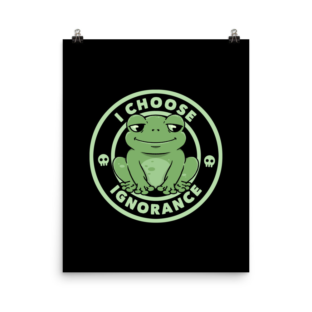 The image shows a cartoonish green frog with a sly smile, sitting with legs splayed out. Around it, the phrase 'I CHOOSE IGNORANCE' is written in bold letters. Two small skull designs are included, one on each side of the frog. The style is playful and ironic, blending elements of humor and rebellion.