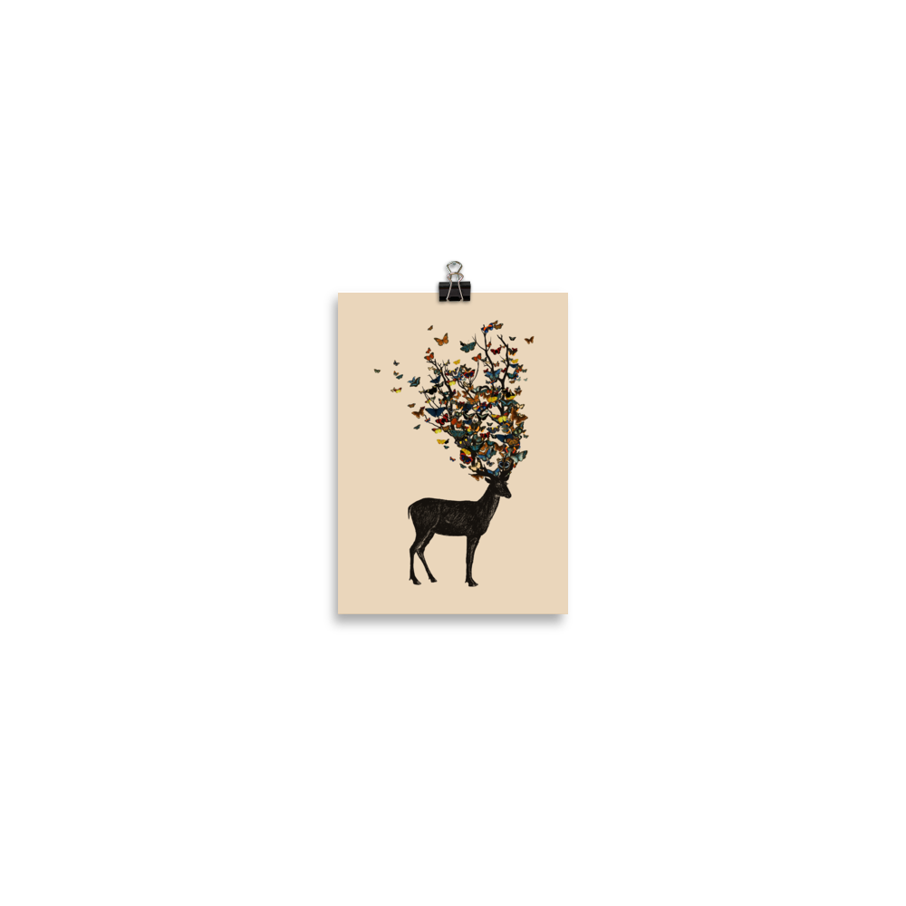 The image depicts a dark, silhouetted deer standing on a neutral background. Instead of branches, its antlers transform into a swirling cloud of vibrant, colorful butterflies that extend upwards and outward. The mix of organic and ethereal elements creates a captivating and whimsical visual contrast.