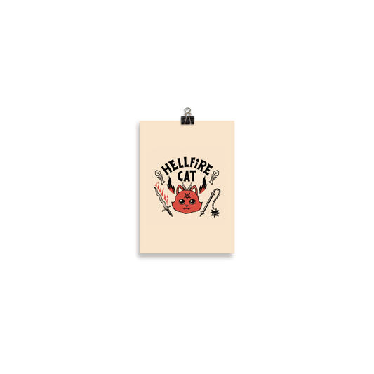 Vintage-style illustration of a cute red devil cat with small horns and a pentagram on its forehead, surrounded by flames, weapons, fish skeletons, and the bold phrase “Hellfire Cat” in a playful gothic design.