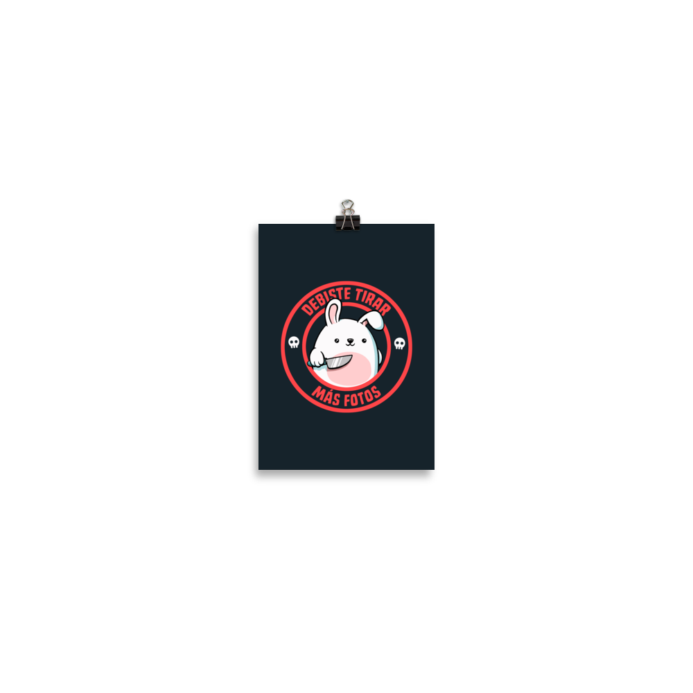 A cute white cartoon bunny with a pink belly stands holding a large kitchen knife in one paw. Surrounding the bunny is a red circular border with the words 'DEBISTE TIRAR MÁS FOTOS'. Small skull icons are on either side of the circle. The overall tone is a mix of adorable and ironic humor.