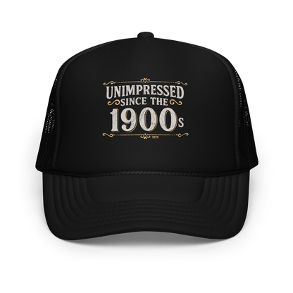 Vintage-style graphic with the phrase “Unimpressed Since the 1900s” in bold distressed lettering, decorated with ornate flourishes and a retro color palette.