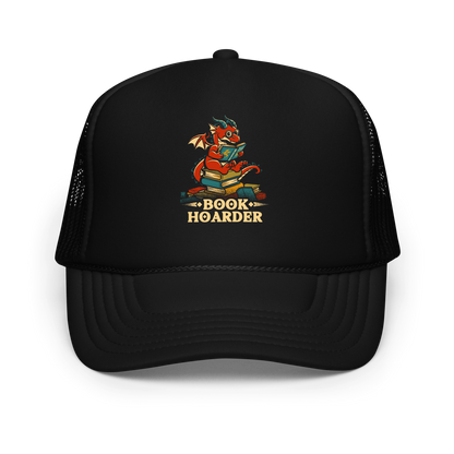Perched atop his treasure trove of books, this red nerdy dragon is ready to devour epic adventures, magic tales, and fantasy worlds. The words 'BOOK HOARDER' are placed at the bottom of the design.