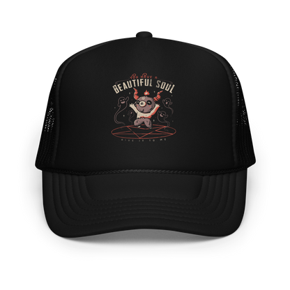 This design features a cute, cartoonish character with horns and a pentagram on its forehead, standing on a red circle with ghost-like figures surrounding it. Above the character, the text reads 'You have a beautiful soul,' and below, 'Give it to me.' The design contrasts dark and cute imagery with playful lettering.