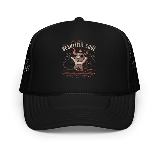 This design features a cute, cartoonish character with horns and a pentagram on its forehead, standing on a red circle with ghost-like figures surrounding it. Above the character, the text reads 'You have a beautiful soul,' and below, 'Give it to me.' The design contrasts dark and cute imagery with playful lettering.