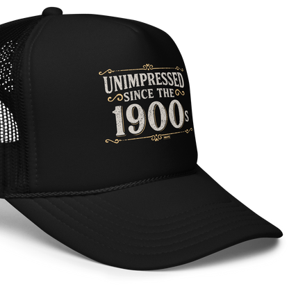 Vintage-style graphic with the phrase “Unimpressed Since the 1900s” in bold distressed lettering, decorated with ornate flourishes and a retro color palette.